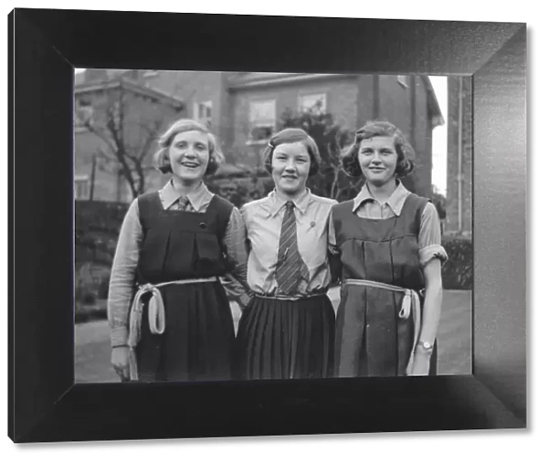 Three girls in school uniform in a garden