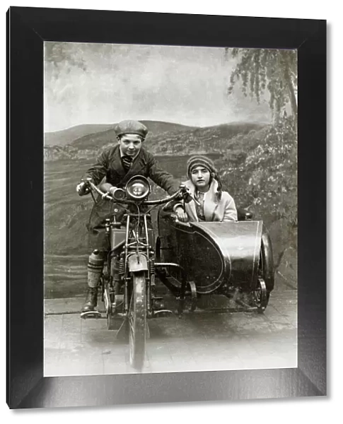 Boy & girl on a 1922 Royal Enfield motorcycle & sidecar in a