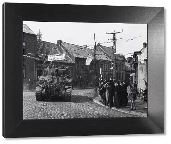 British armour enter Belgium, one of the first tanks passing through the village of