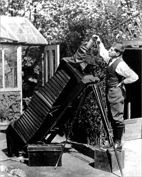 Reginald Malby with a giant camera in his garden