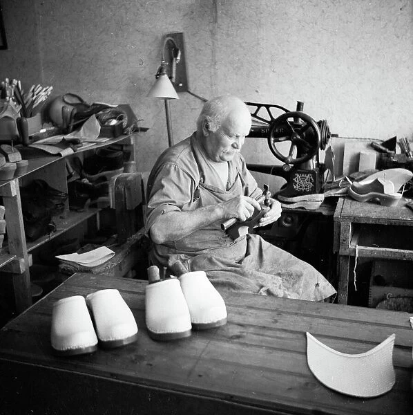 Cobbler. Making a wooden shoe. Date: 1950s
