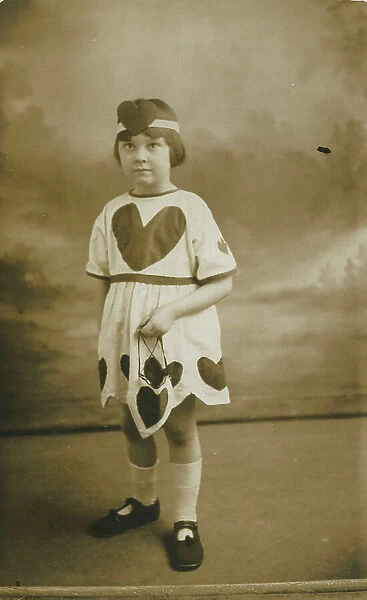Delightful photograph of a little girl called Margaret dressed in a costume embellished with love hearts. Date: 1926