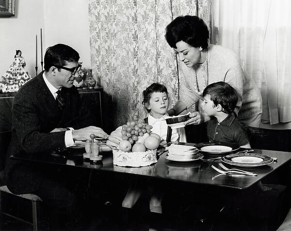 Family seated at the dinner table 1960s