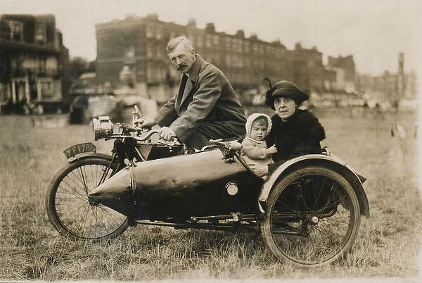 Gentleman, lady & baby pose on unknown motorcycle