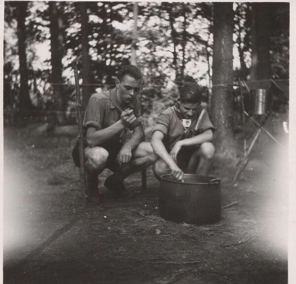 Two German boy scouts cooking at camp