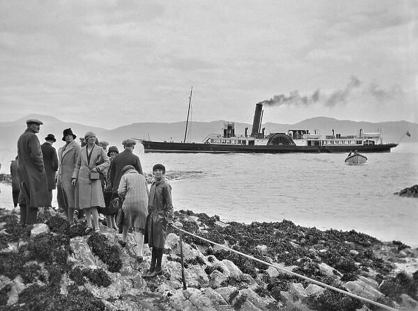 Group of people on shore with steamboat on the sea