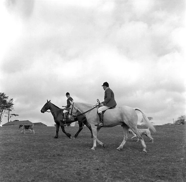 Hunt members, horses and dogs in a field