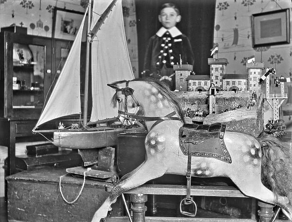Little boy with rocking horse, sailing boat and castle