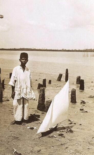 A Malaysian boy with a toy yacht