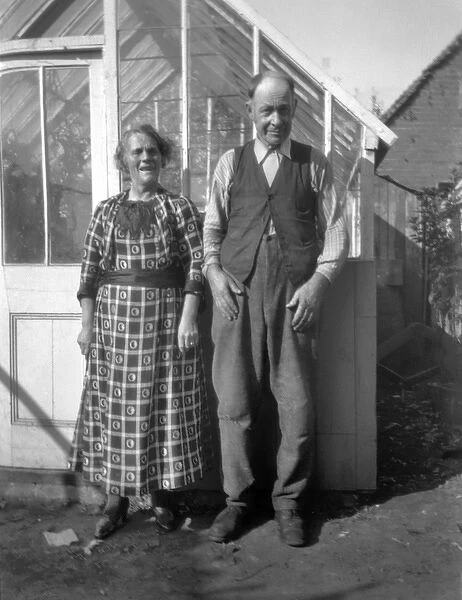 Middle-aged couple standing in front of greenhouse