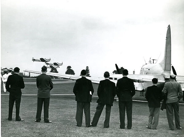 Three Miles Magisters fly past the de Havilland Dove, G-?