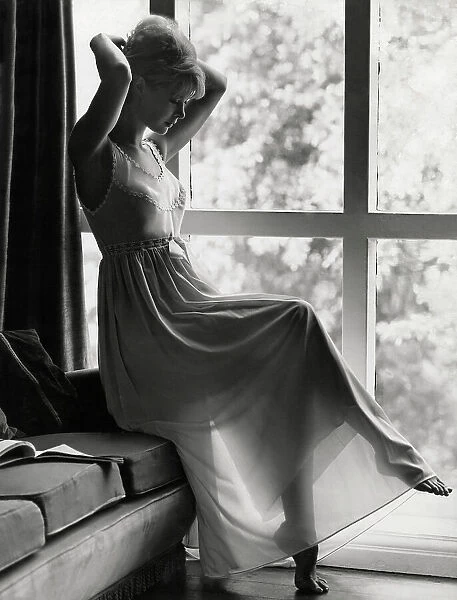 Model indoors in elegant nightgown with sheer skirt