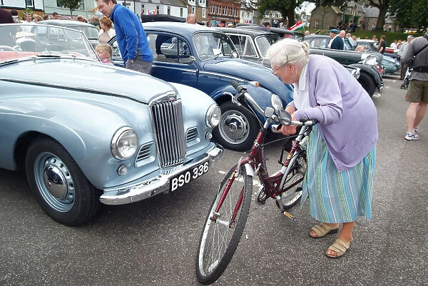 An old lady stops to look closely at a vintage motor car