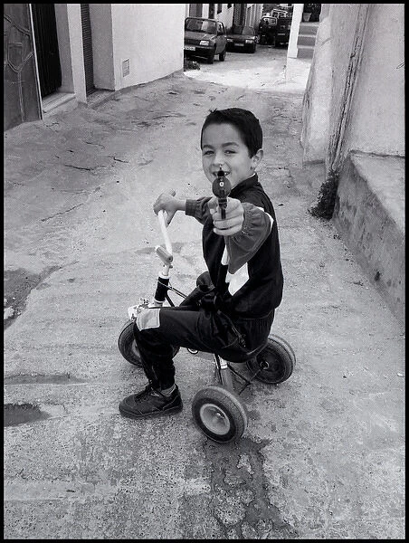 Small boy pointing a toy gun, Malaga, Spain