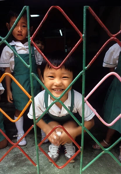A small child behind the grill of a kindergarten, Hong Kong