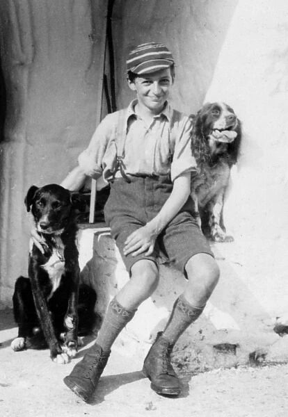 A smiling schoolboy and his two dogs