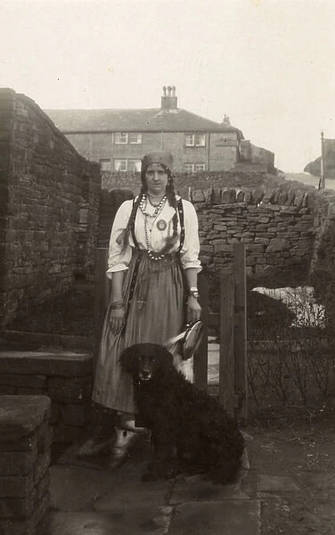 Woman in gipsy costume with a dog in a garden