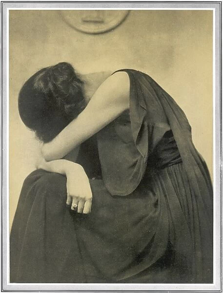Grief. A woman holds her head in her arms in this camera study by Hugh