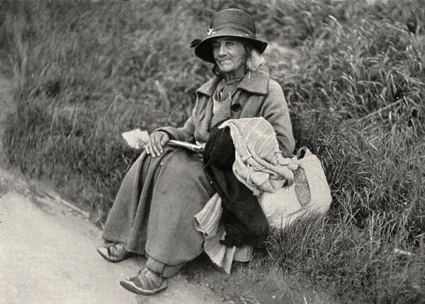 Woman tramp sitting at side of road