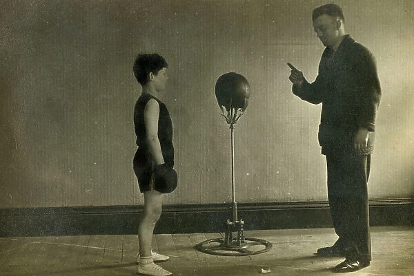 Young Boxer receiving instruction from his Trainer in a gym