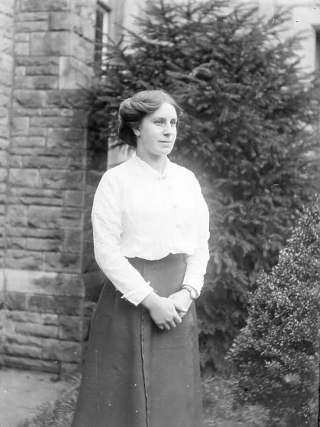 Young Edwardian woman standing in a garden, Mid Wales