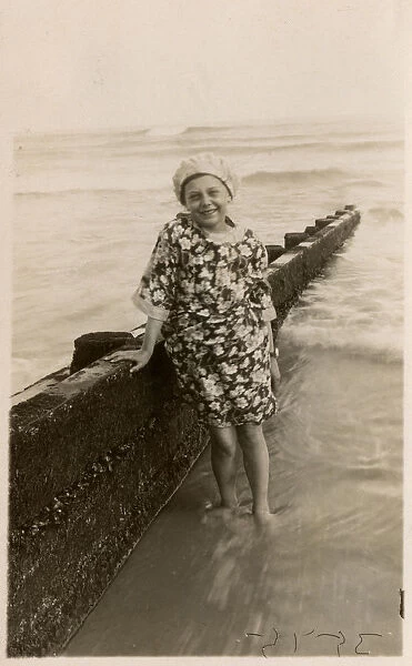 Young girl at the seaside in floral dress and bathing cap