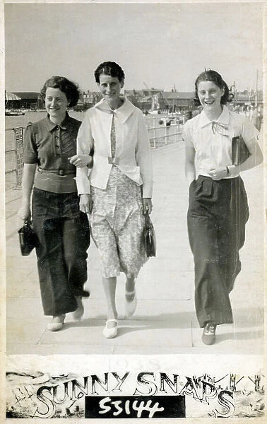 Three young ladies strolling along the seafront