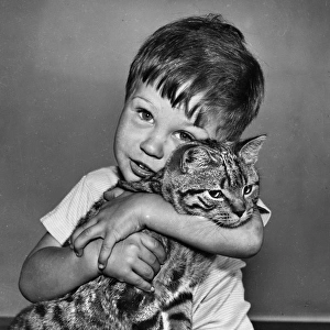 Boy hugging a large tabby cat