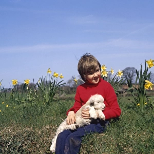 Boy with spring lamb and daffodils