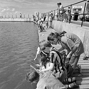 Children crabbing from a wooden pontoon at New Brighton