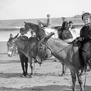 Children riding donkeys on a beach, probably in Atlantic Cit