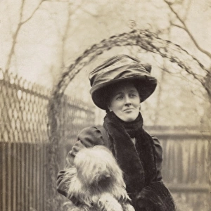 Edwardian woman holding a terrier in a garden