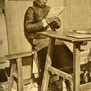Elderly man reading at a table, Shanghai, China, East Asia