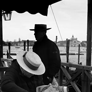 Two gondoliers wait for tourist clients at St Marks, Venice
