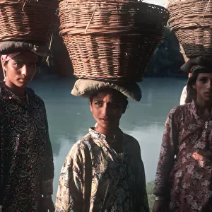 Kashmiri women wearing Kashmiri shirts with baskets of reeds