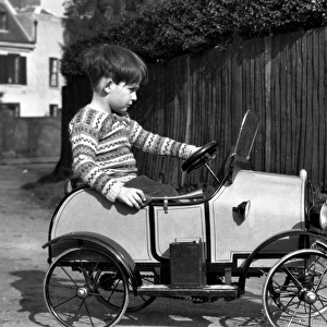 Little boy riding in a toy car