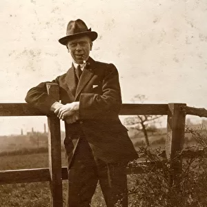 Man leaning on a fence in the countryside