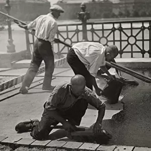 Men asphalting a street. Date: 1930s