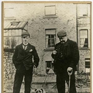 Two men with bulldog in a back garden