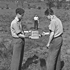 Three men with model plane in a field