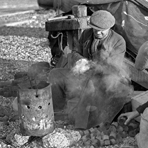 Two men sitting by a smoking brazier
