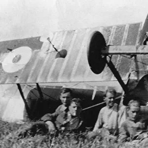 Four men with upturned biplane in field, WW1
