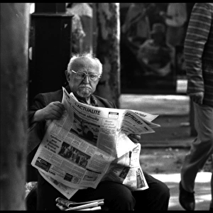 Old man in street, Paris with newspaper