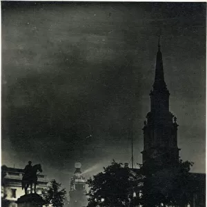 Trafalgar Squre by night, London. Date: circa 1909
