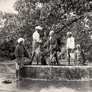 Water carriers filling their skins in a well, India