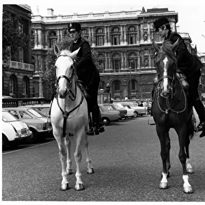 Two women police officers mounting horses, London