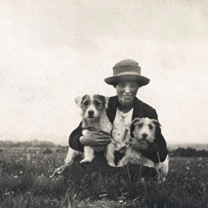 Young woman in a field with two terrier dogs