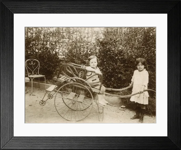 Framed Print : Two girls playing with a push cart Framed Print : Two girls playing with a push cart