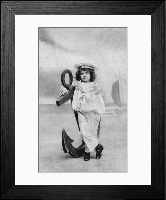 Framed Print : Small boy in a sailor suit poses with a large anchor Framed Print : Small boy in a sailor suit poses with a large anchor