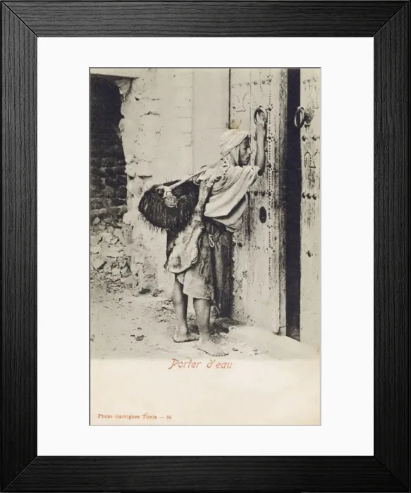 Framed Print : Tunisia, Water Carrier knocking at an impressive wooden door Framed Print : Tunisia, Water Carrier knocking at an impressive wooden door